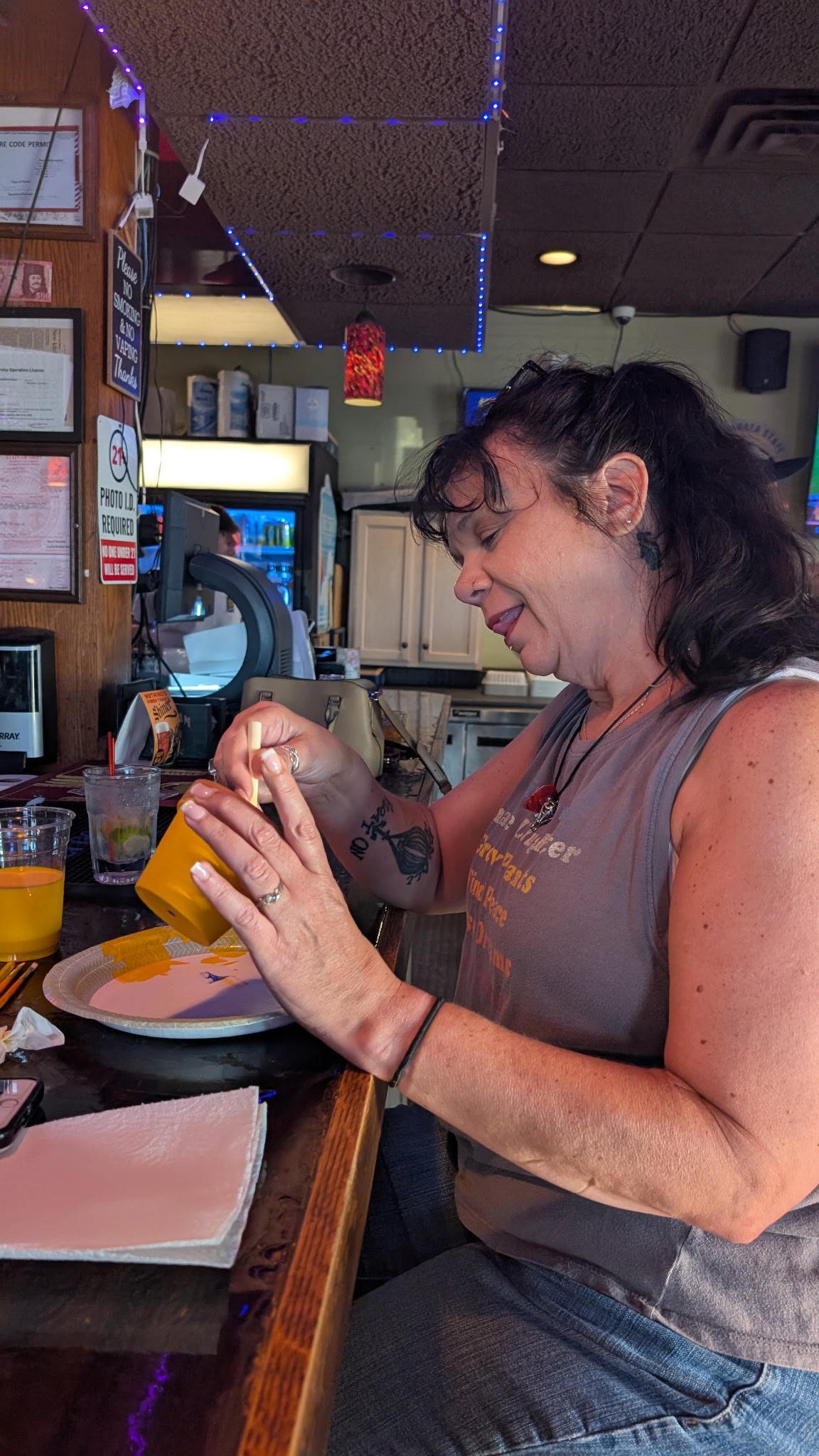 A guest painting a bright yellow craft project inside the bar