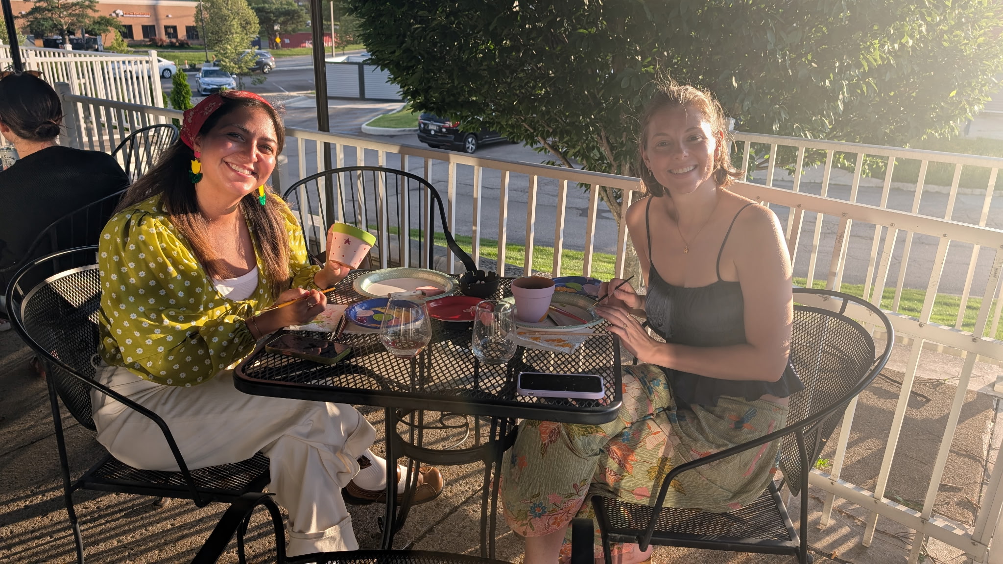 Two guests painting together on the covered patio at sunset